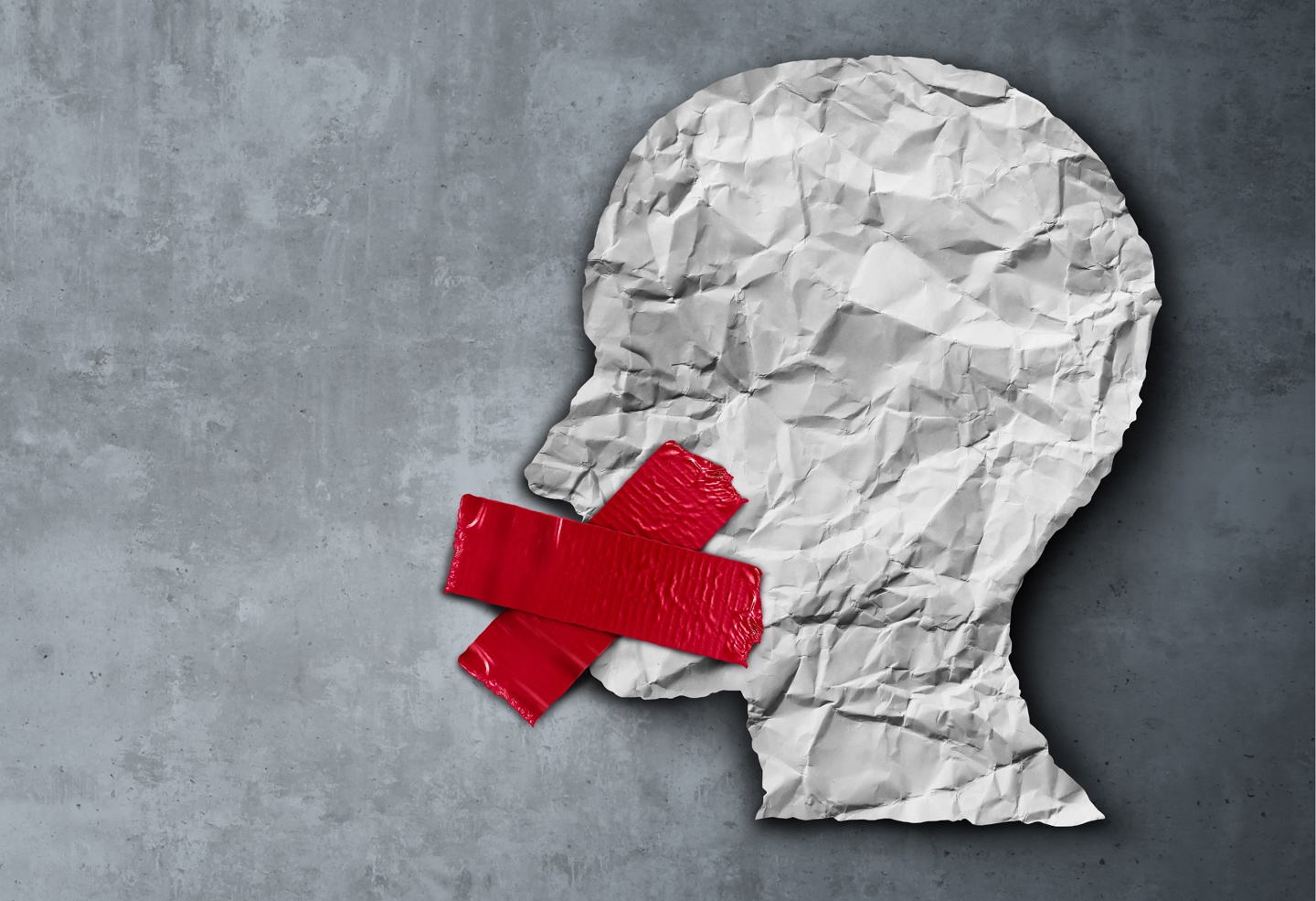 En papirfigur av et hode med rød tape over munnen.