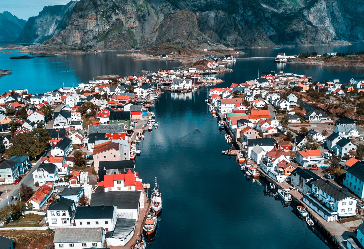 Liten by omringet av fjell og fjord.