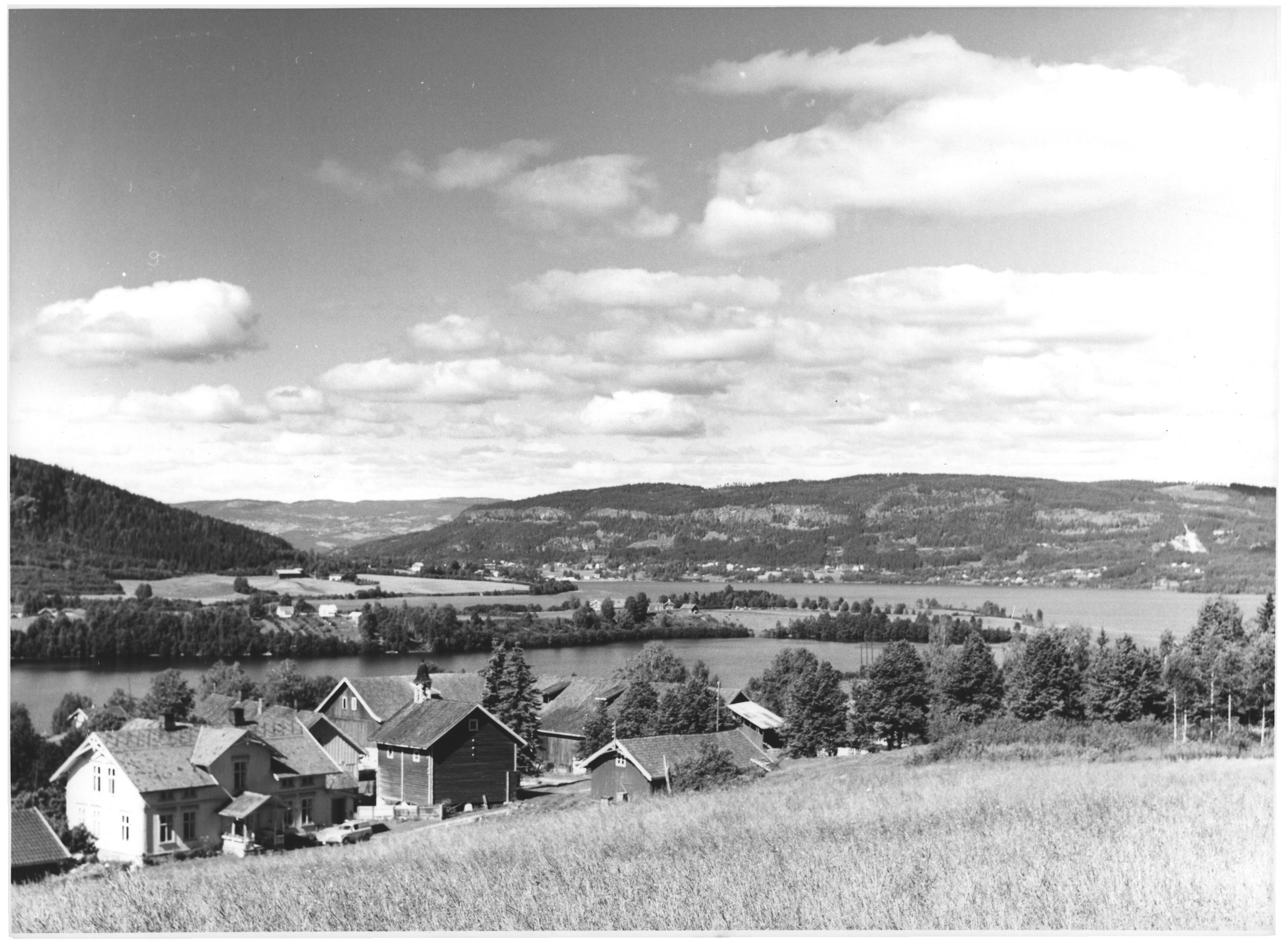 Svart hvitt bilde av hus og åker ved Randsfjorden.