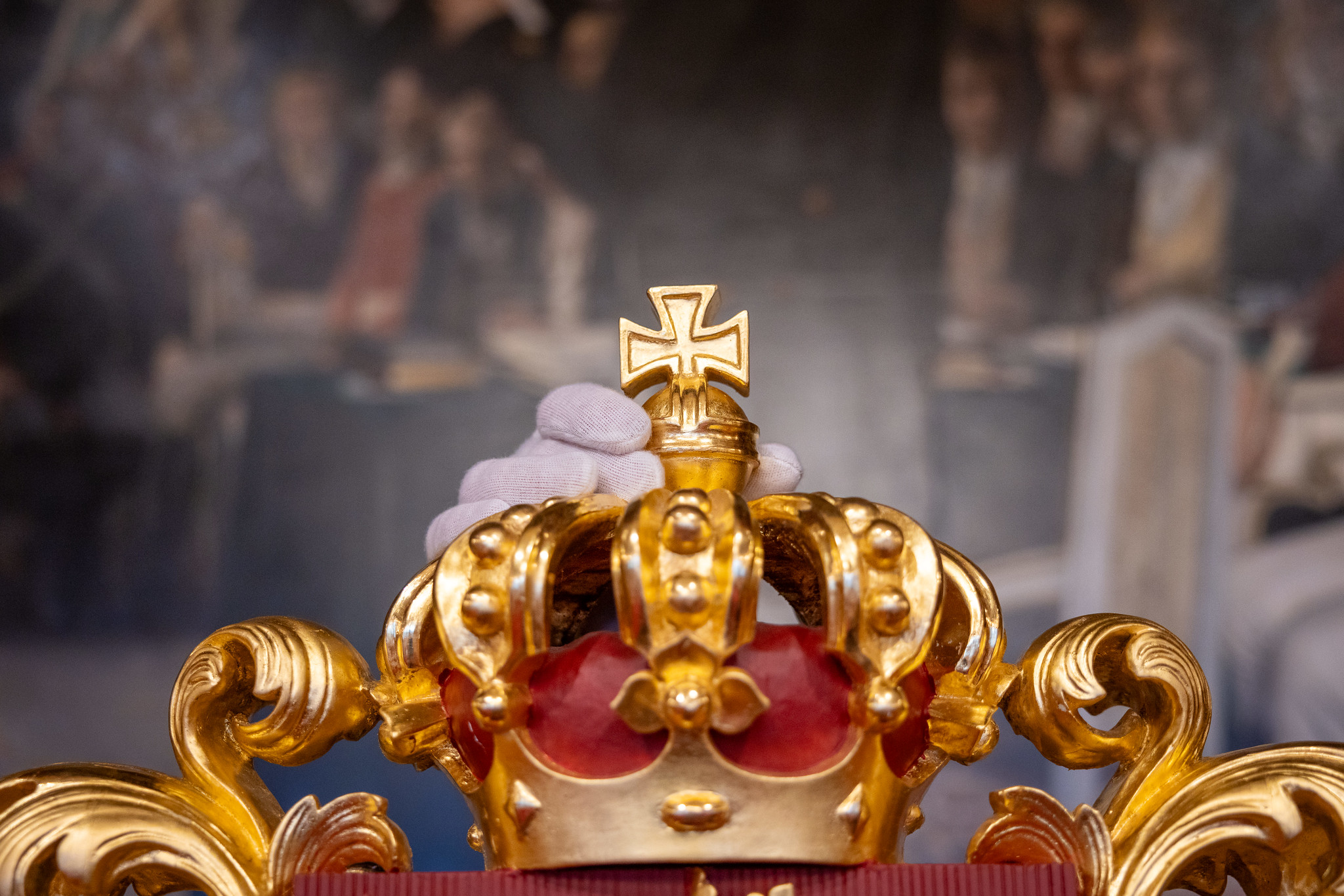 Et kors plasseres på kongens stol i stortingssalen.