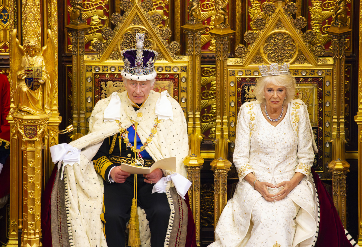 Kong Charles og Dronning Camilla sitter på tronstoler i det britiske parlamentet.