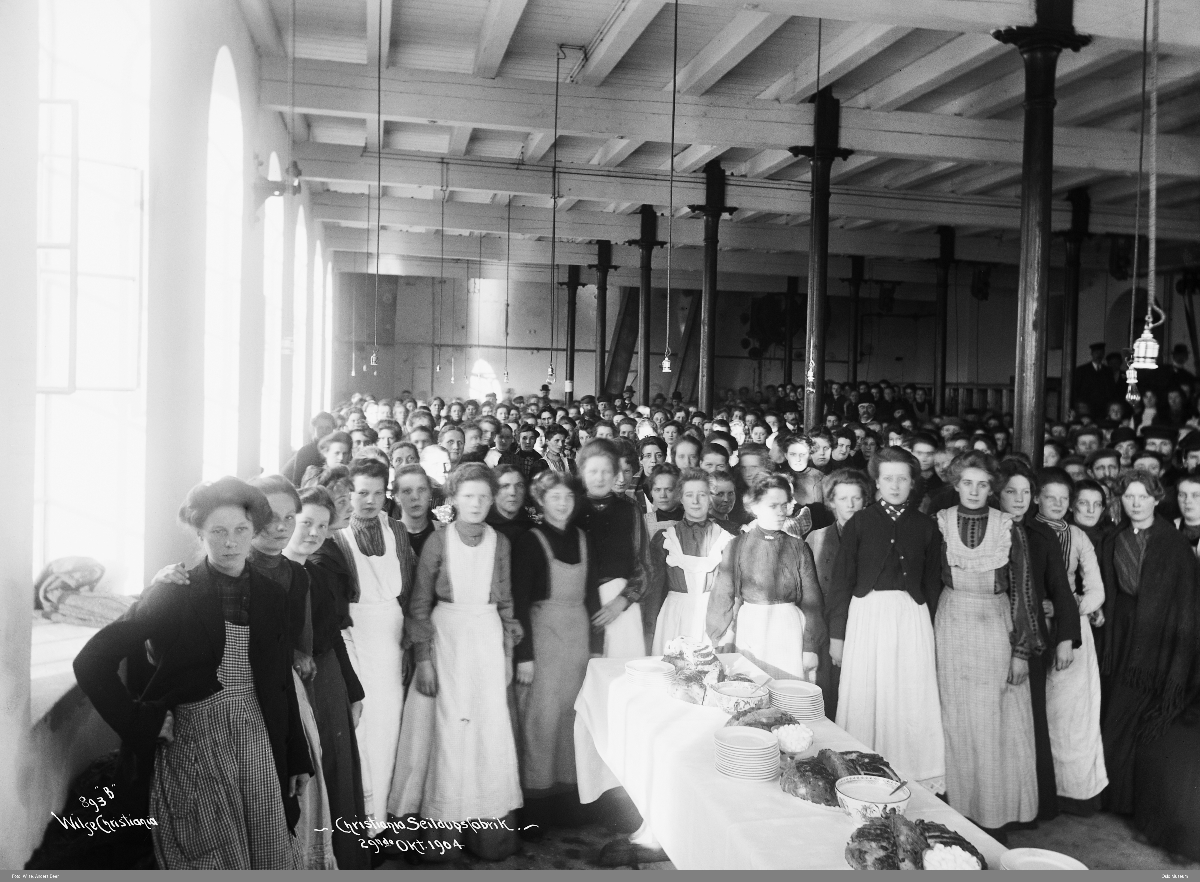 Svarthvitt bilde av kvinnelige arbeidere på fabrikk.