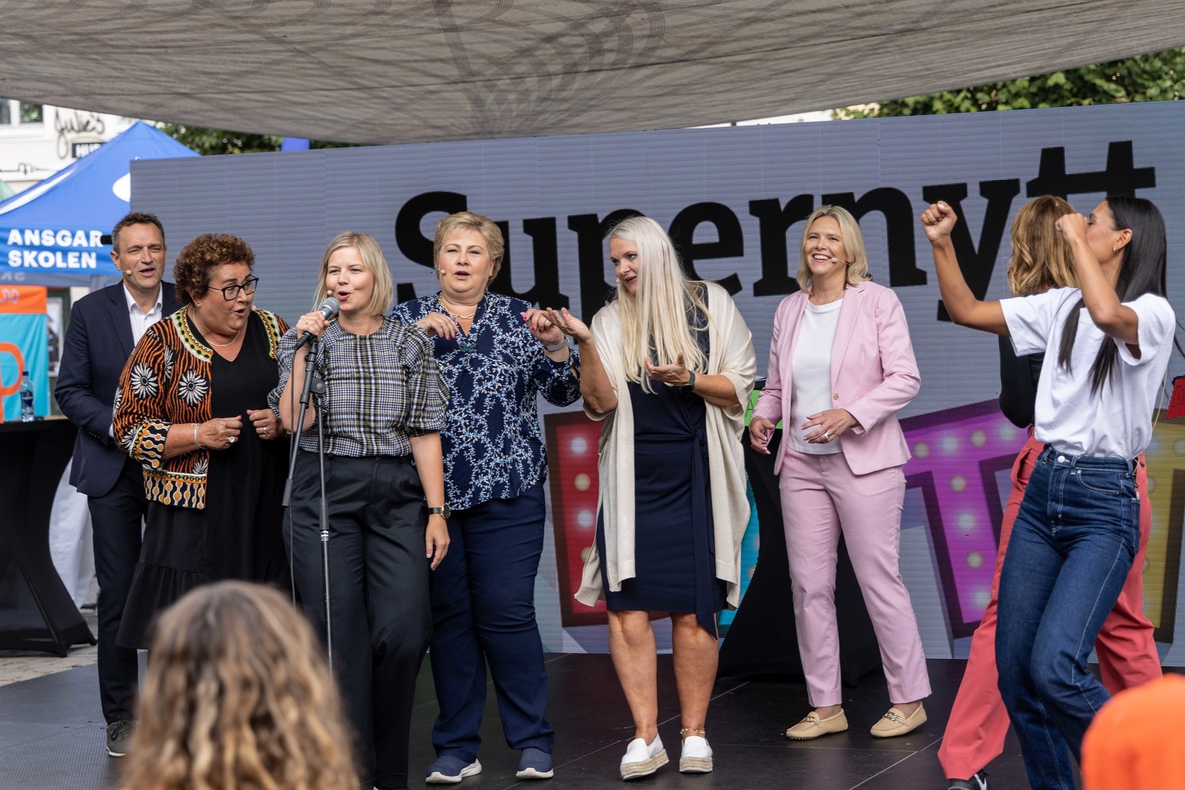 Flere partiledere syngert og danser på en scene.