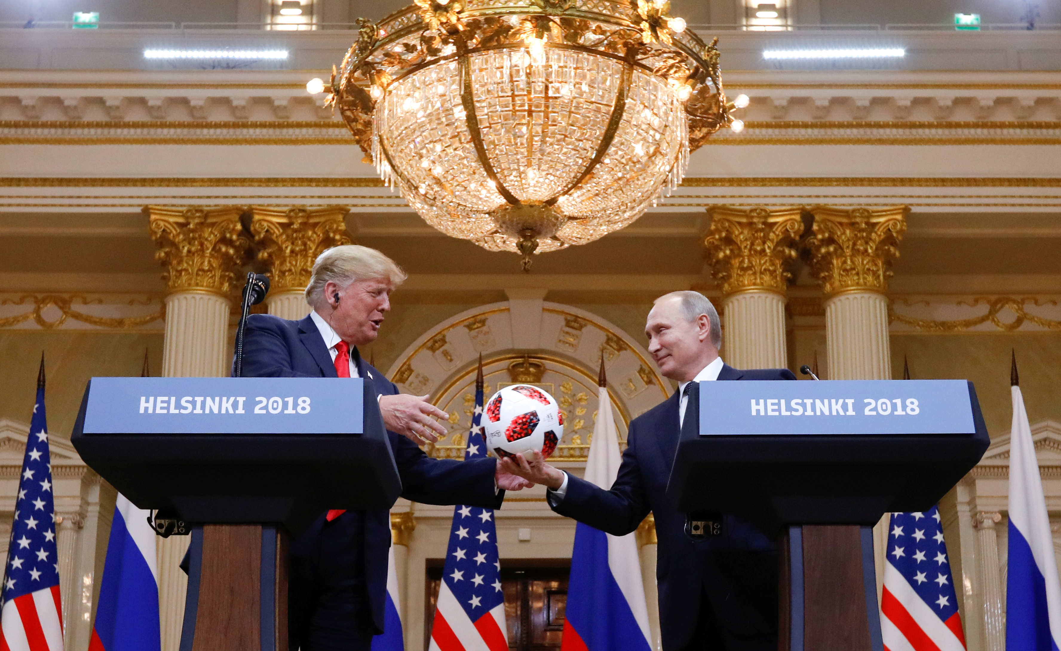 Trump og Putin ved hver sin talerstol. Holder en fotball mellom seg.