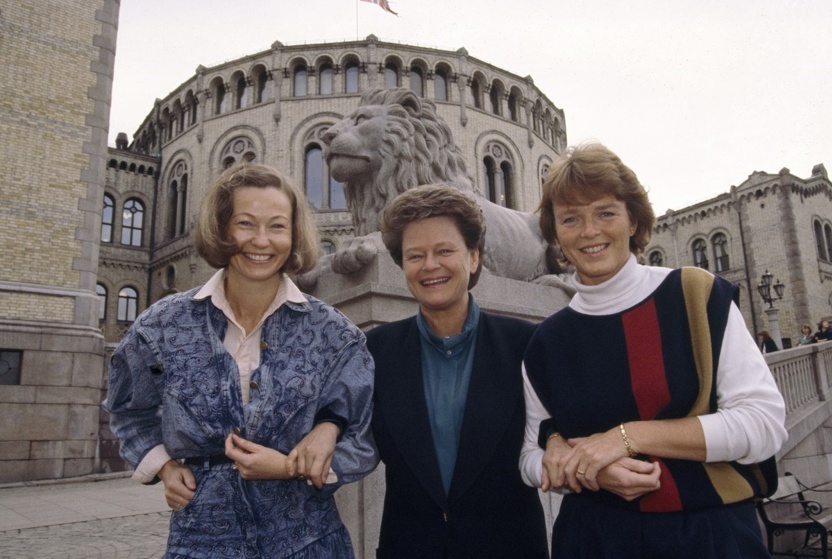 Tre kvinner står foran Stortinget.