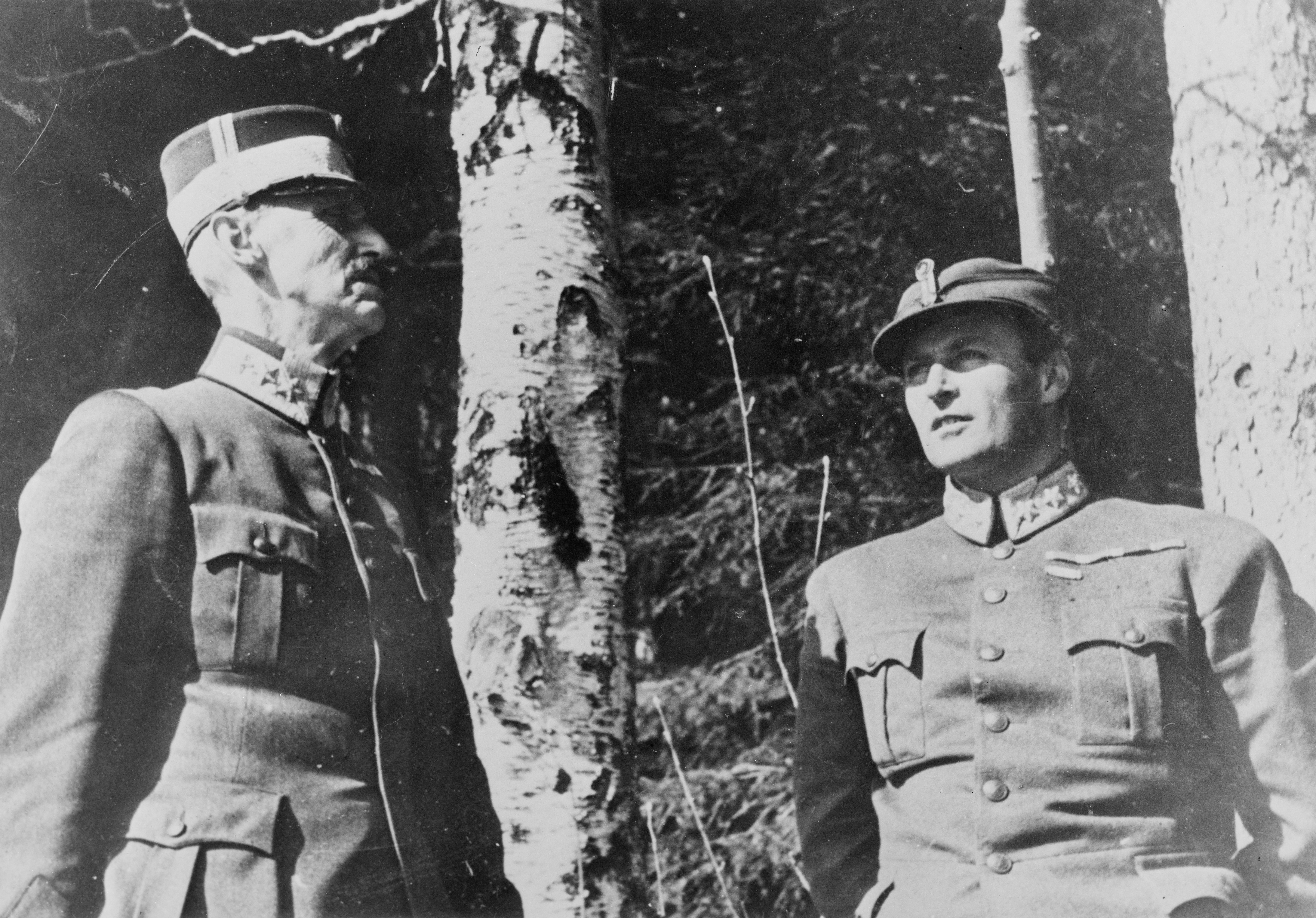 Kong Haakon VII og Kronprins Olav står foran et tre.