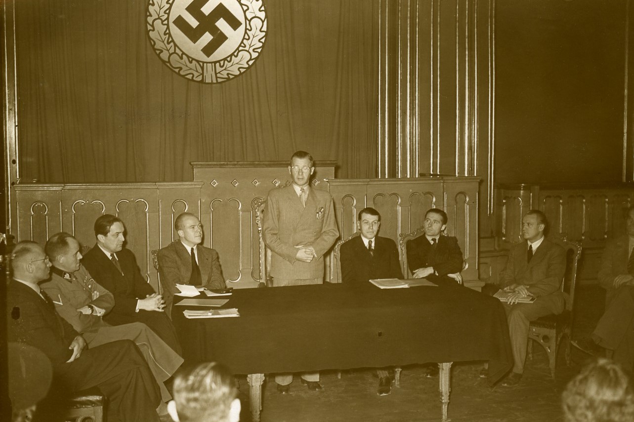 Stortingssalen i bruk av den tyske okkupasjonsmakten under krigen. Et teppe med hakekors-symbol er hengt opp foran Eidsvold 1814-maleriet.