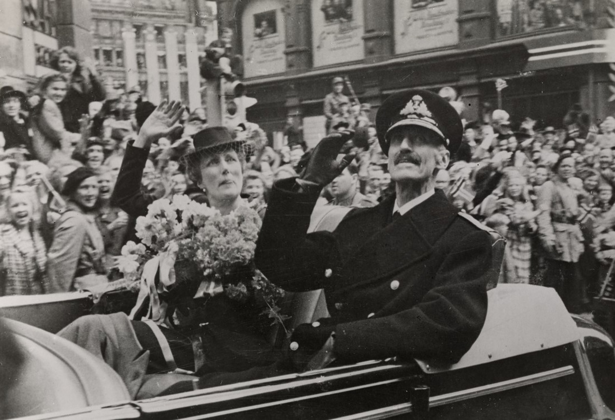 Kong Haakon i bil hilser folkemengden etter frigjøringen.