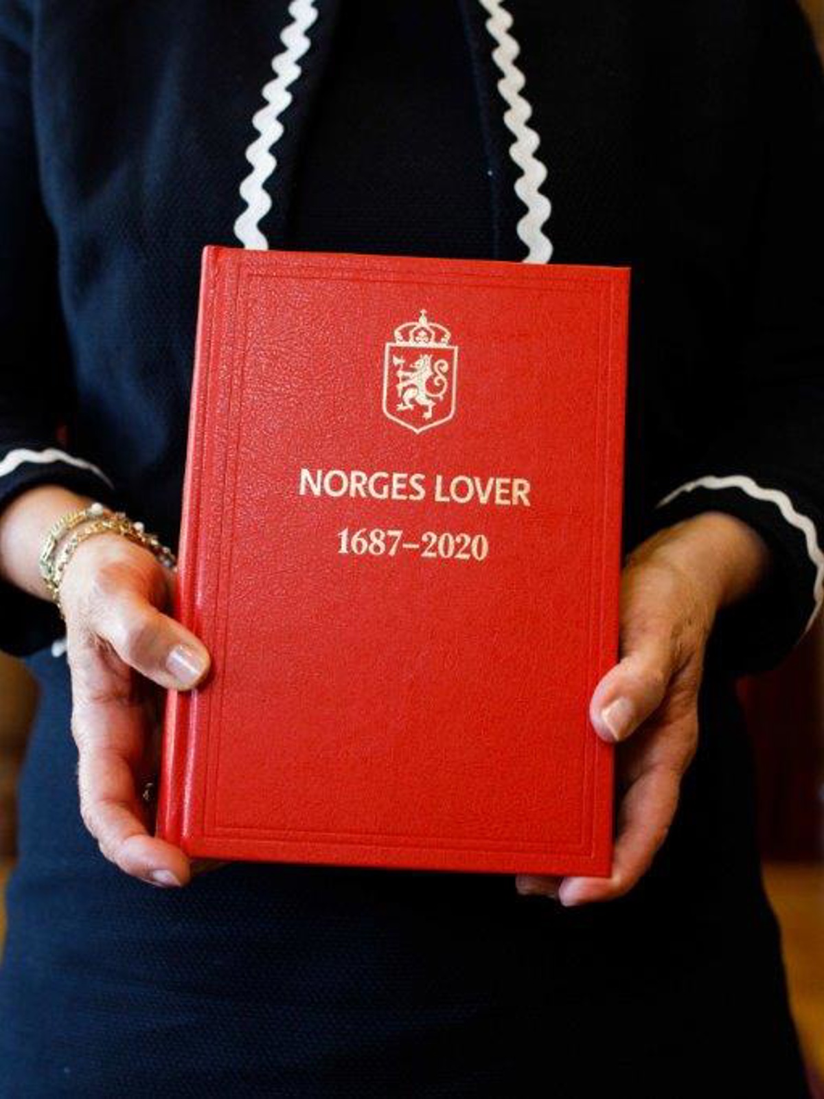 Hender som holder lovbok.