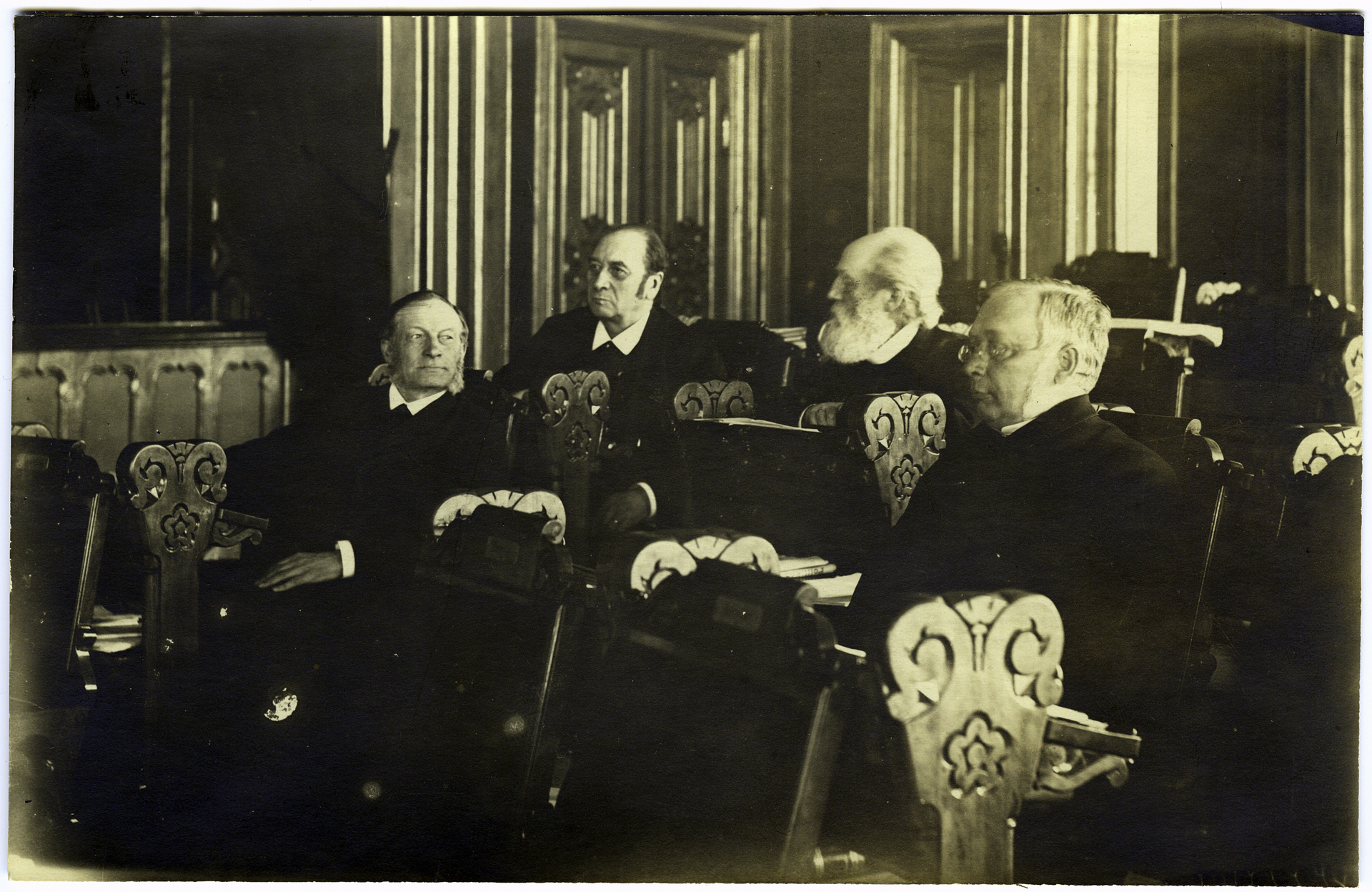 Gammelt bilde av fire representanter i stortingssalen.