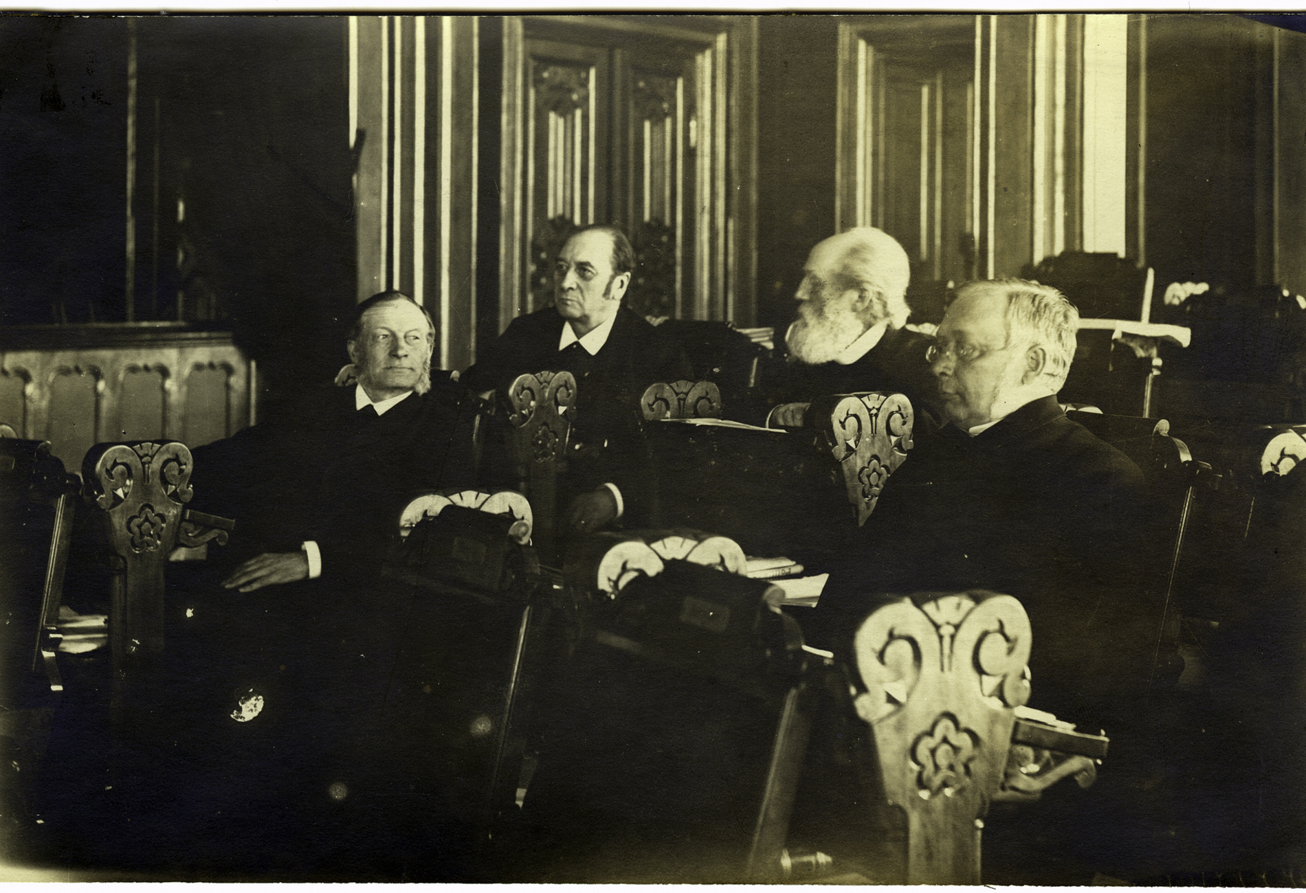 Gammelt bilde av fire representanter i stortingssalen.