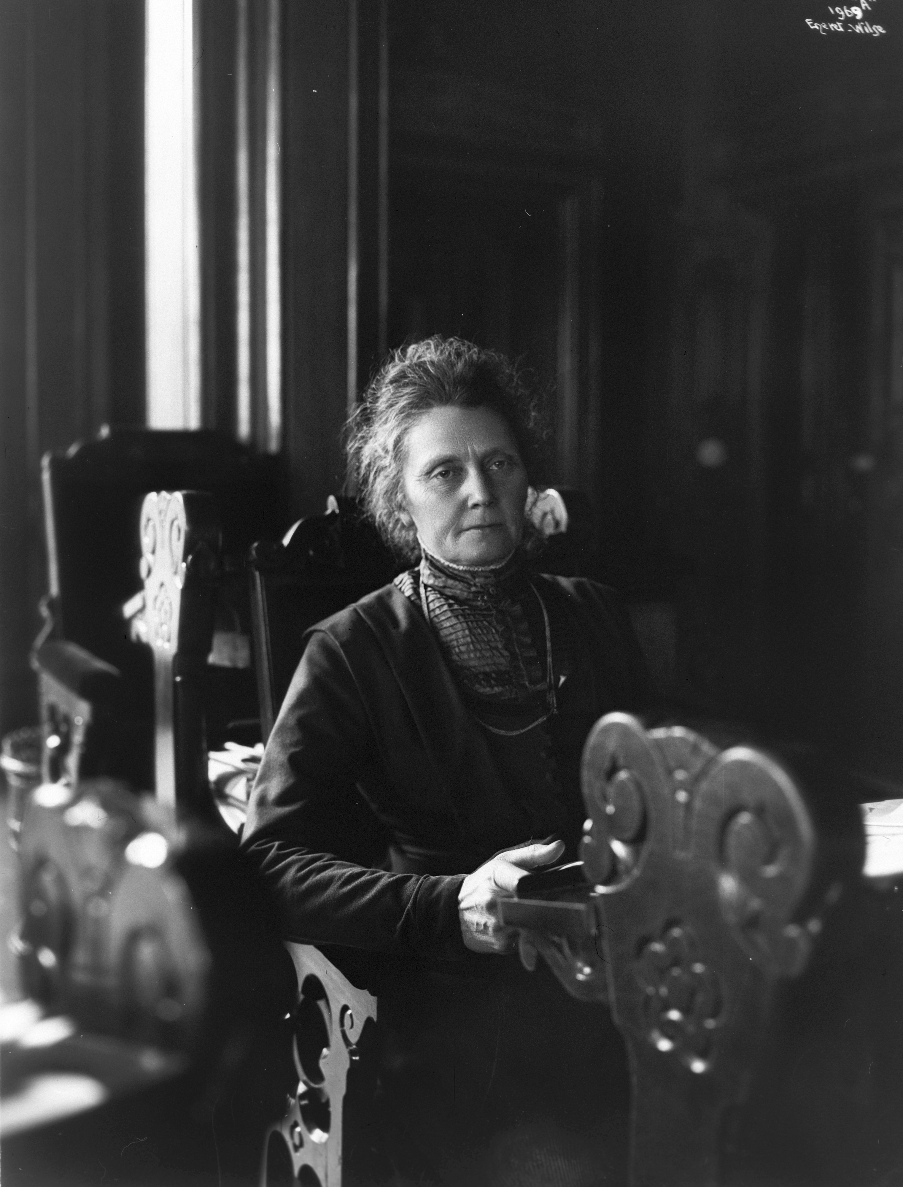 Svart hvitt bilde av en kvinne som sitter i stortingssalen.