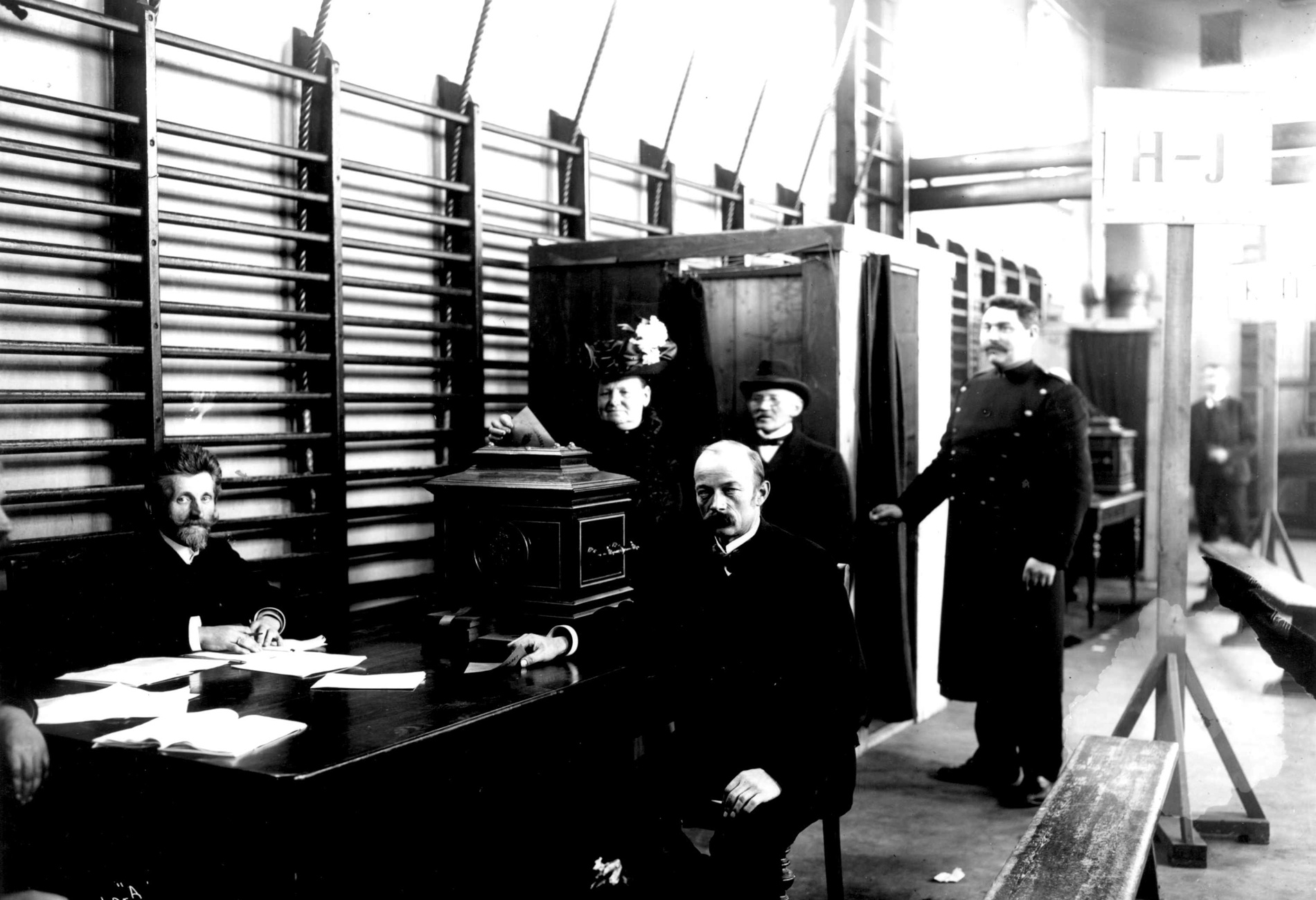 bilde i svart hviit av en mann som avlegger sin stemme i et stemmelokale i 1909.
