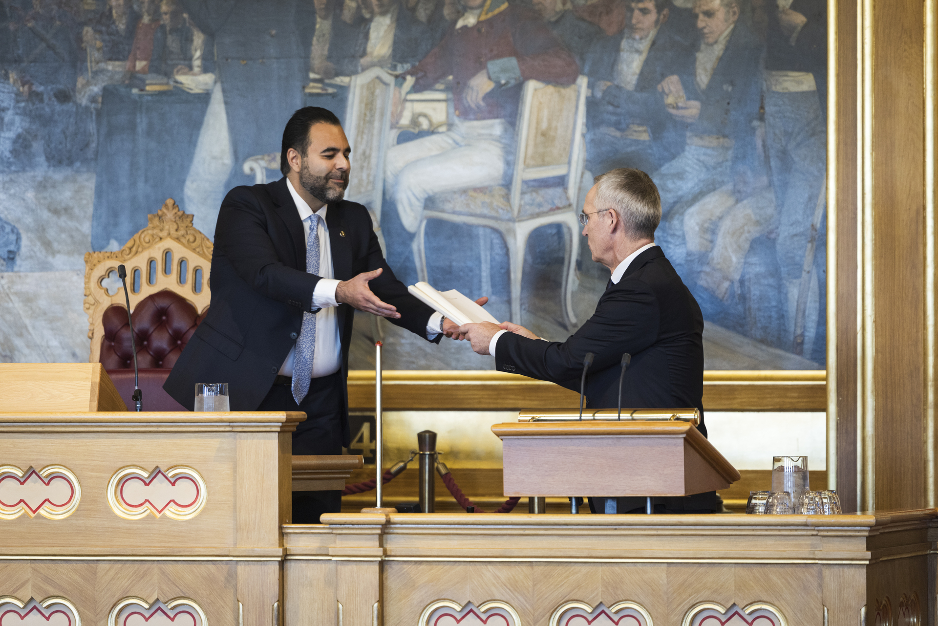 Jens Stoltenberg overleverer en bunke papirer til Masud Gharahkhani.