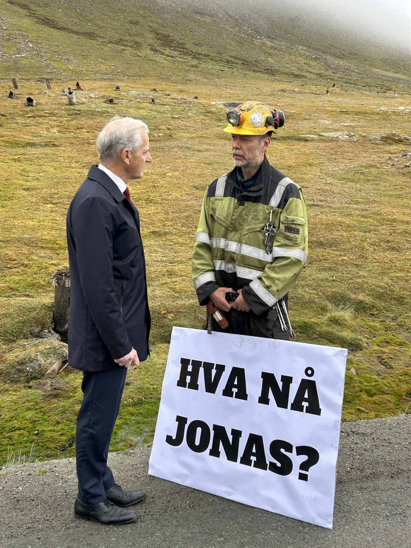 Jonas Gahr Støre møter en mann med et stort skilt hvor det står "Hva nå Jonas?"