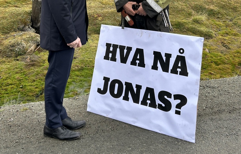 Jonas Gahr Støre møter en mann med et stort skilt hvor det står "Hva nå Jonas?"