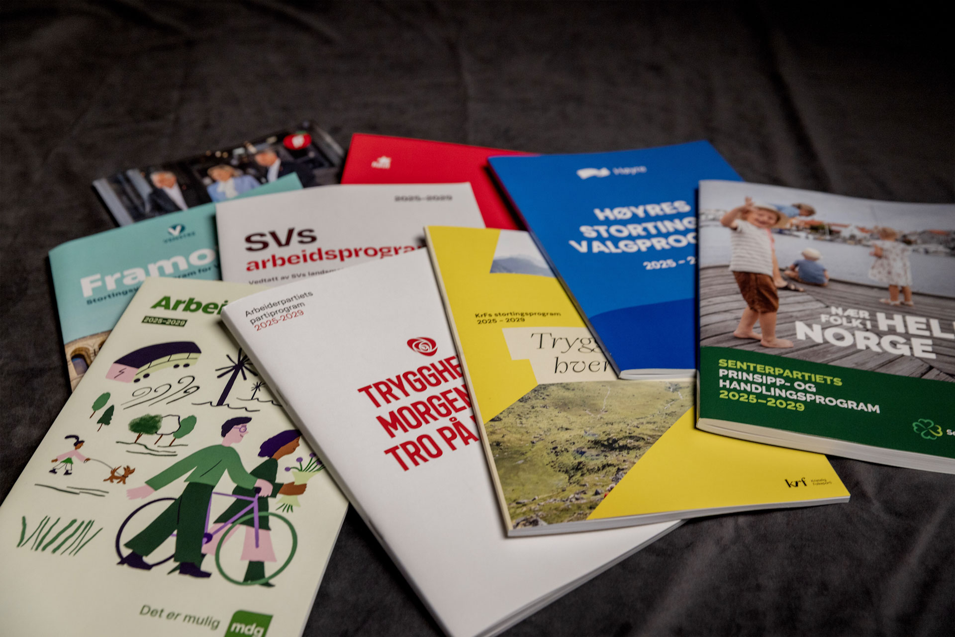 En bunke partiprogram ligger på et bord.