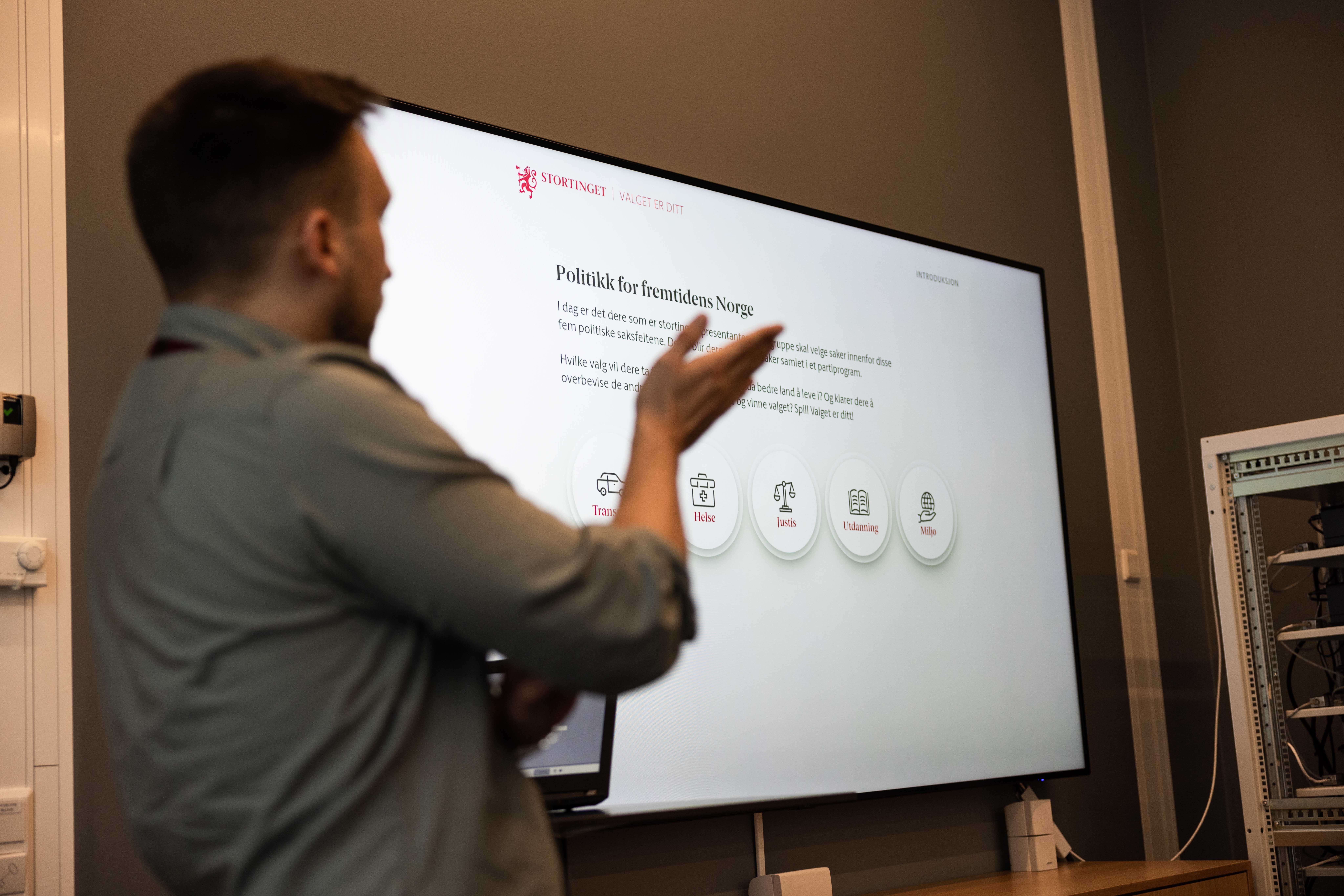 En veileder står ved en skjerm og forklarer