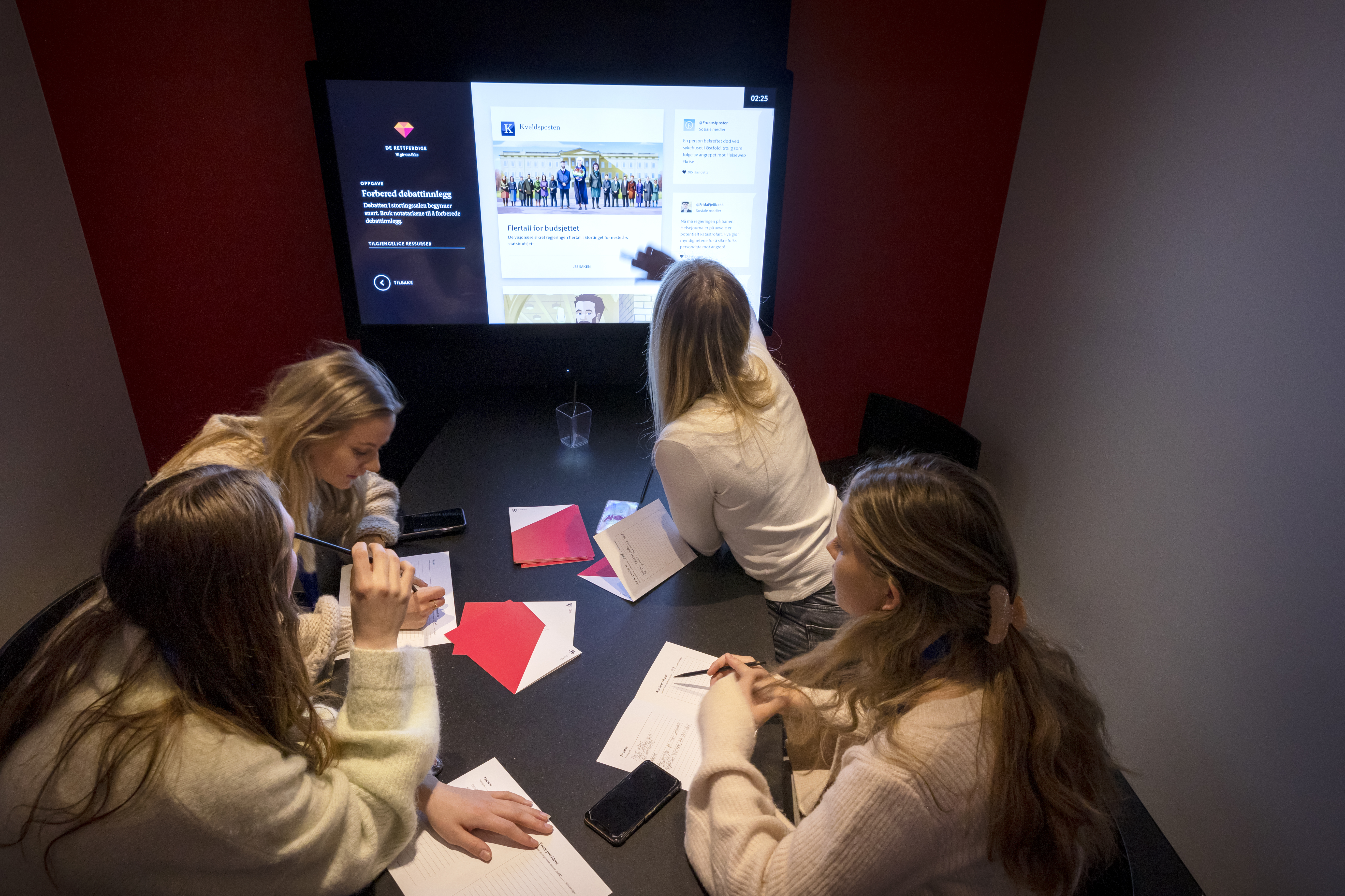 Elever sitter i et grupperom og trykker på en skjerm
