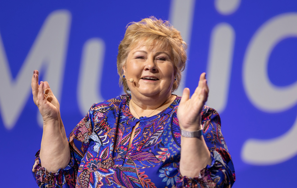 Erna Solberg klapper i hendene og smiler.