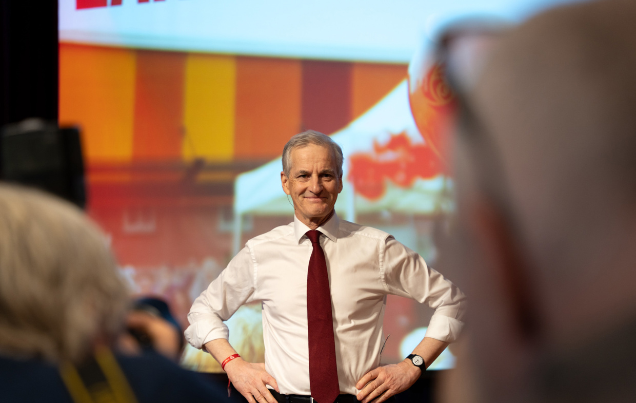 Jonas Gahr Støre smiler foran en folkemengde.