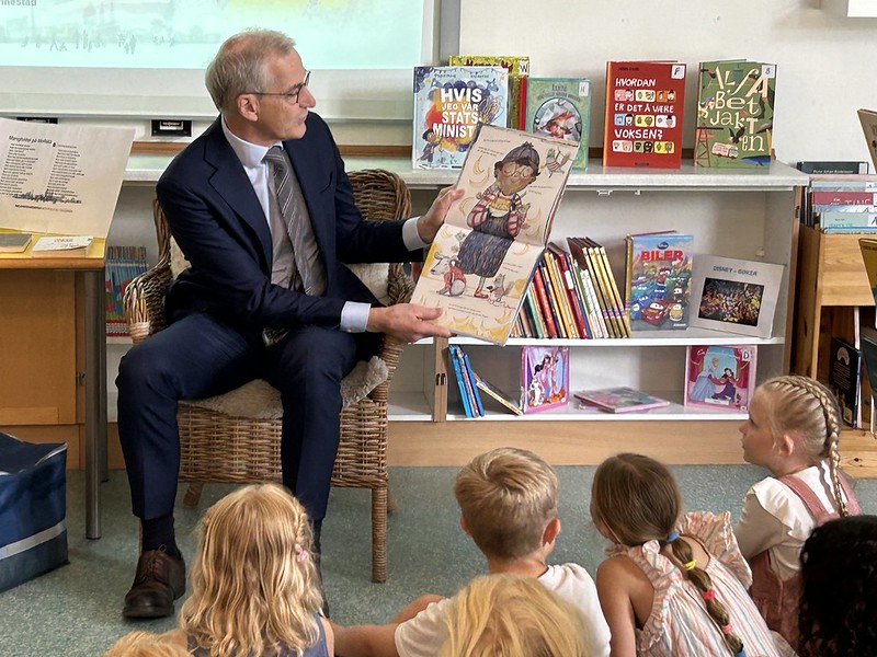 En mann leser for en gruppe barn.