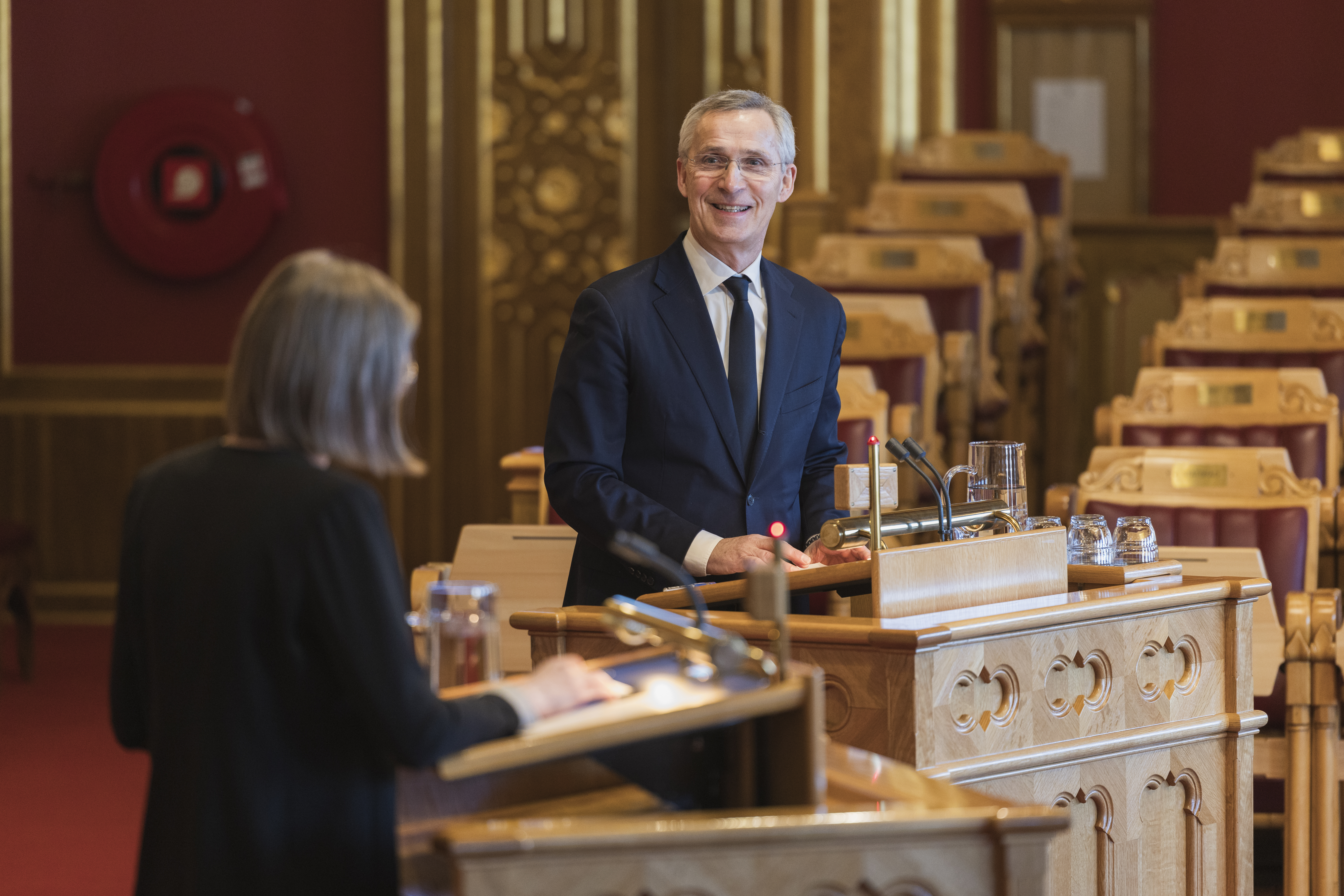 en mann og en dame står på Stortingets talerstoler.