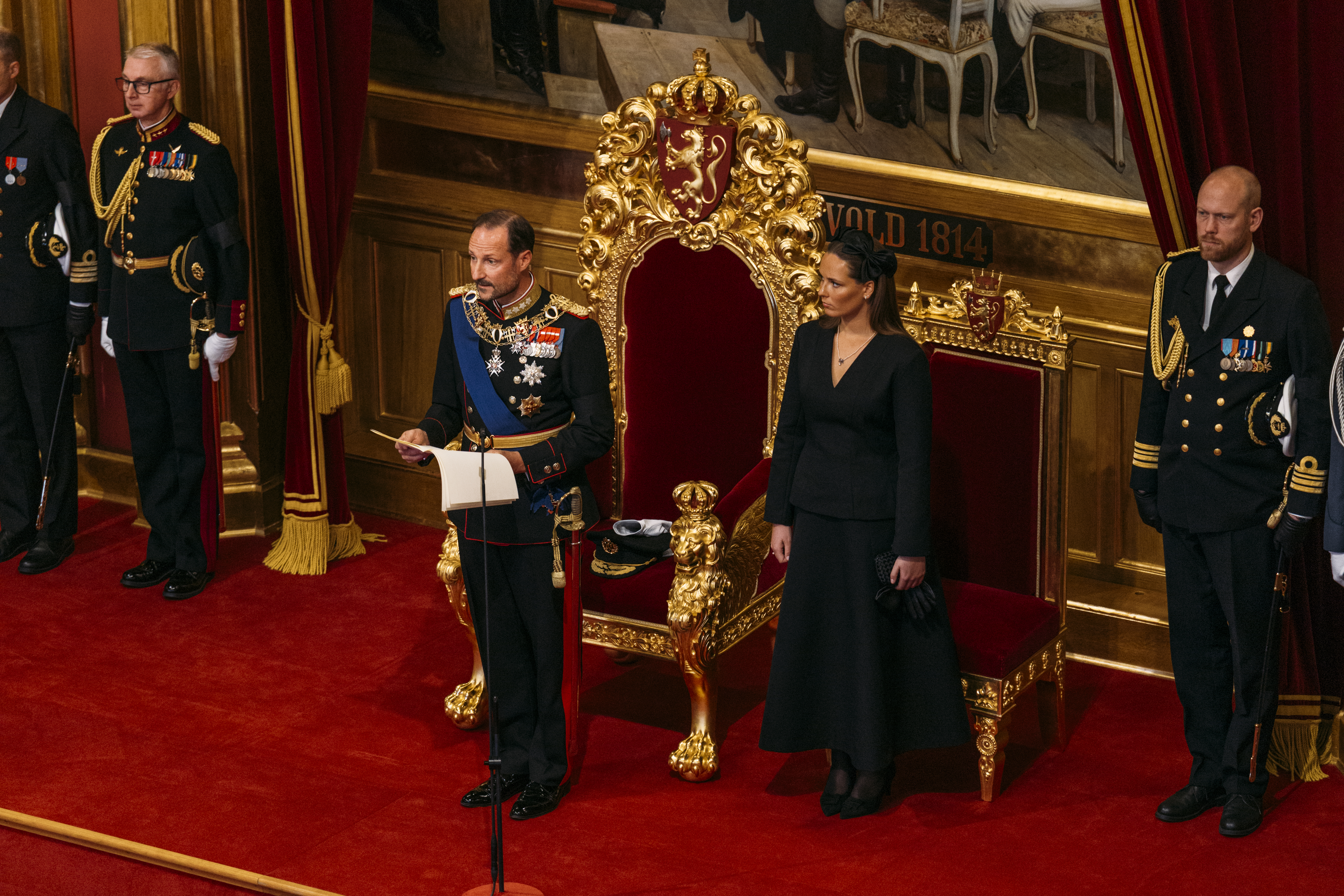 Kong Håkon leser trontalen. Kronprinsessen står ved siden av.