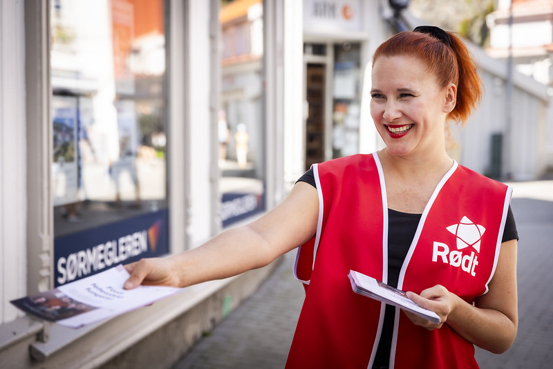 En kvinne fra partiet Rødt deler ut flyers.