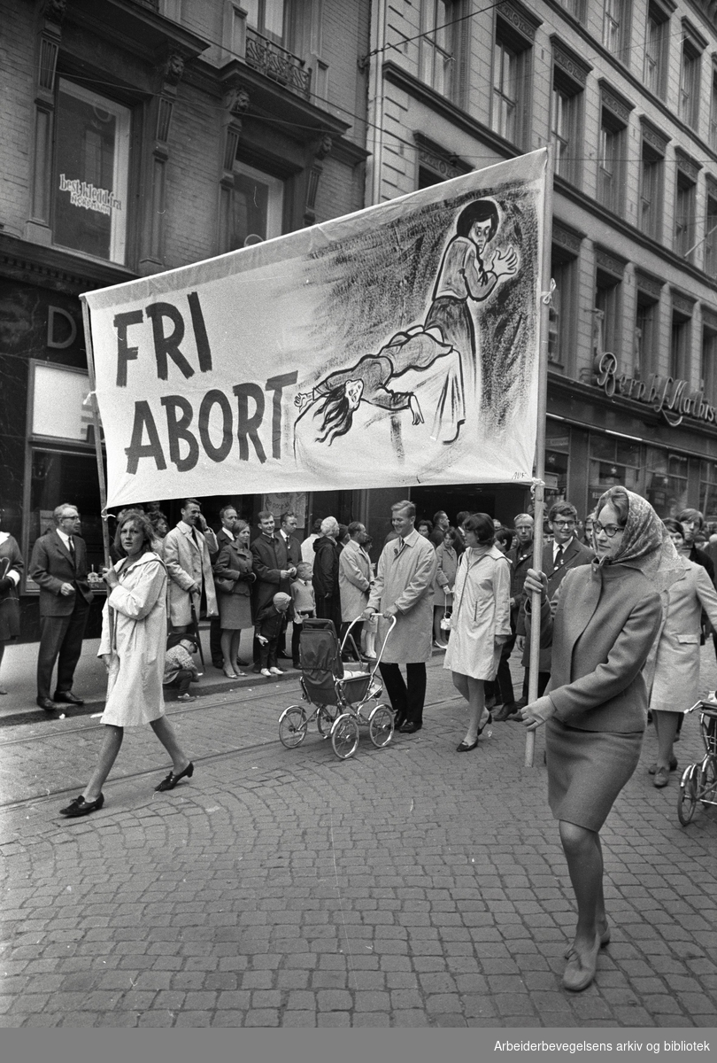 Kvinner og menn demonstrerer 1. mai 1968 under parolen "Fri abort". Foto i svart hvitt.