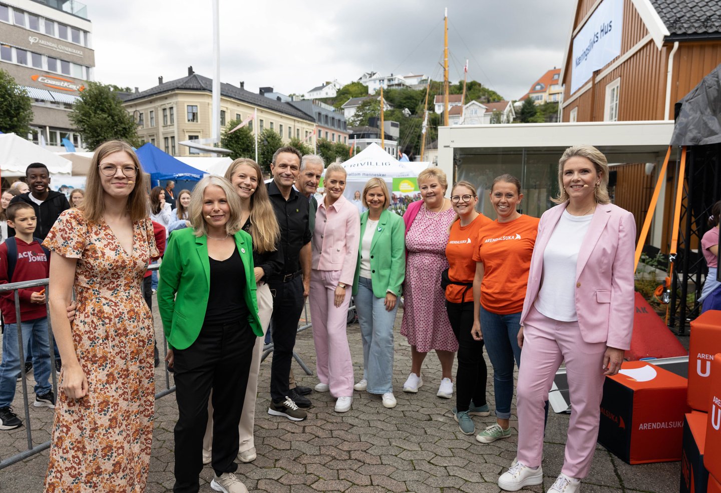 En gruppe mennesker med mikrofon smiler til kamera.