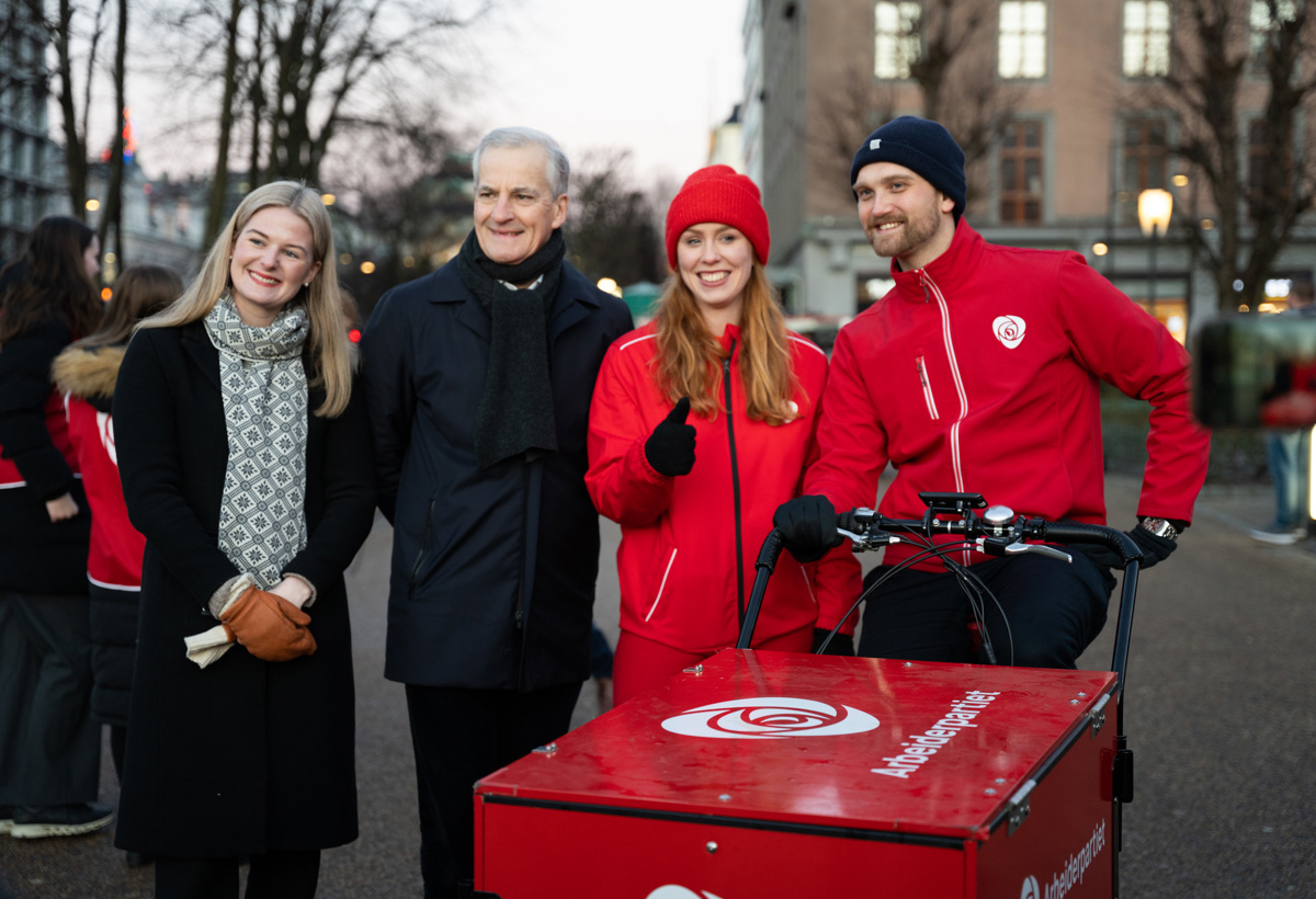 Fire mennesker står ved en tralle der det står Arbeiderpartiet.