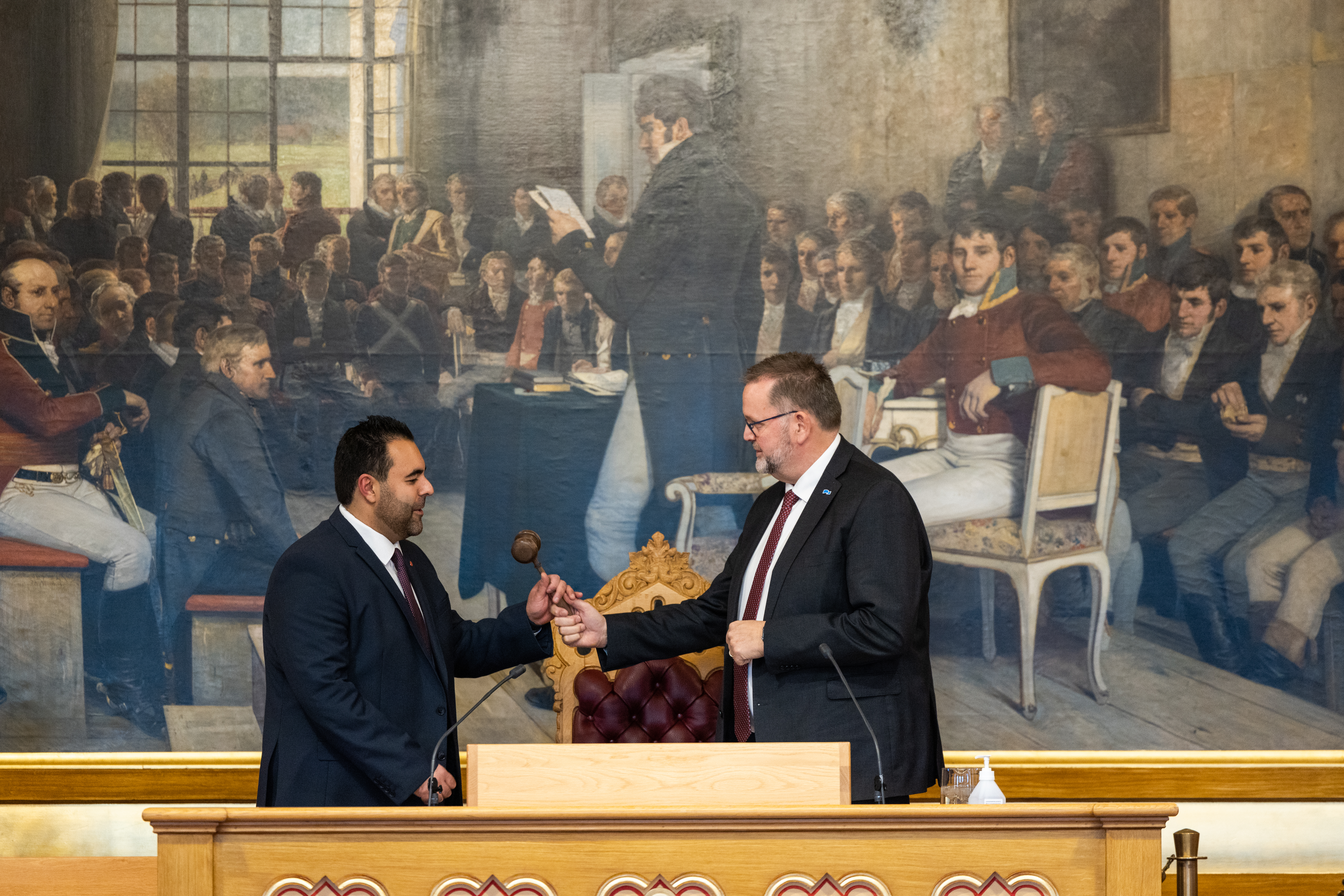 I stortingssalen. En mann gir presidentklubba til en annen mann.