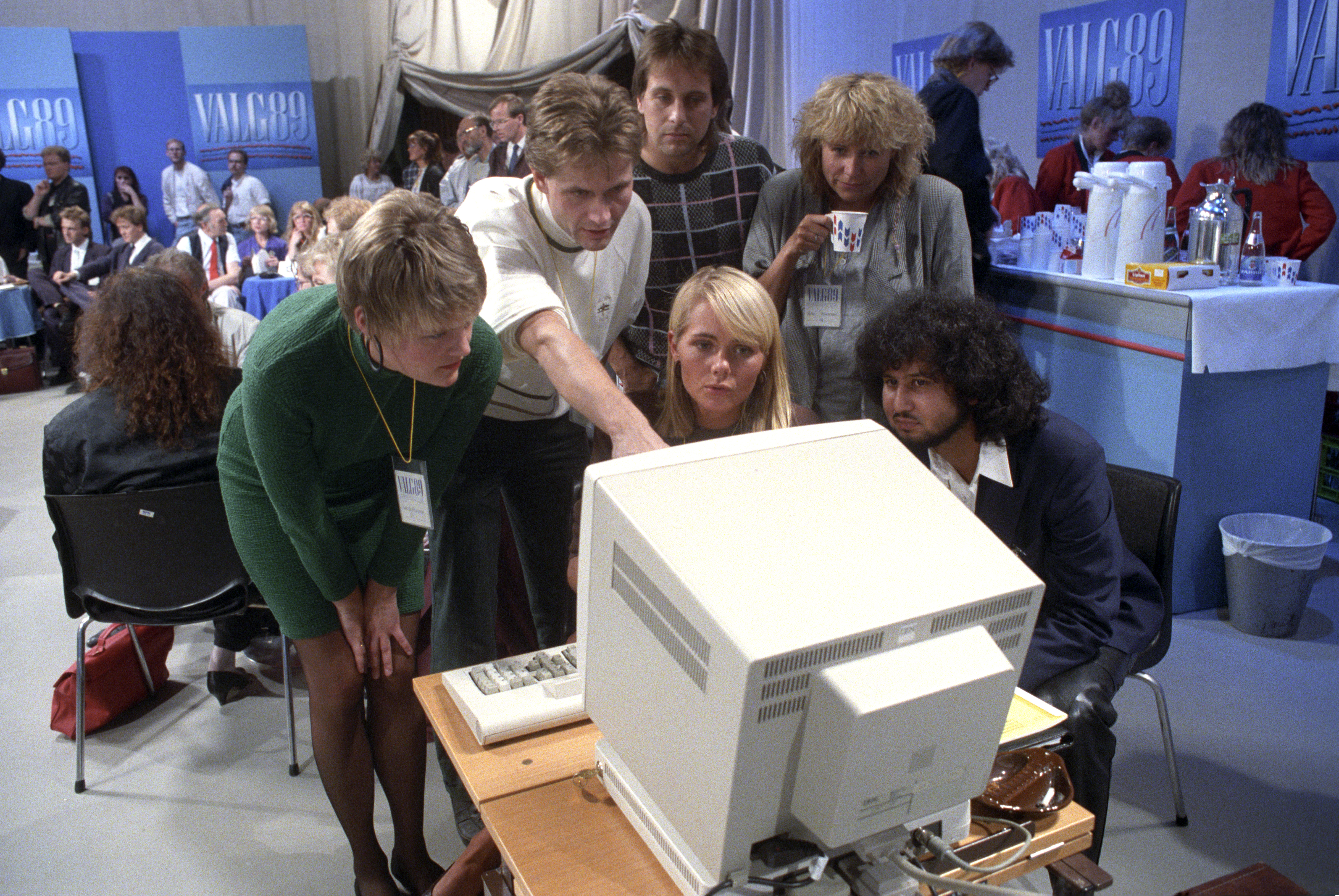 Seks mennesker ser spent på en TV-skjerm. 