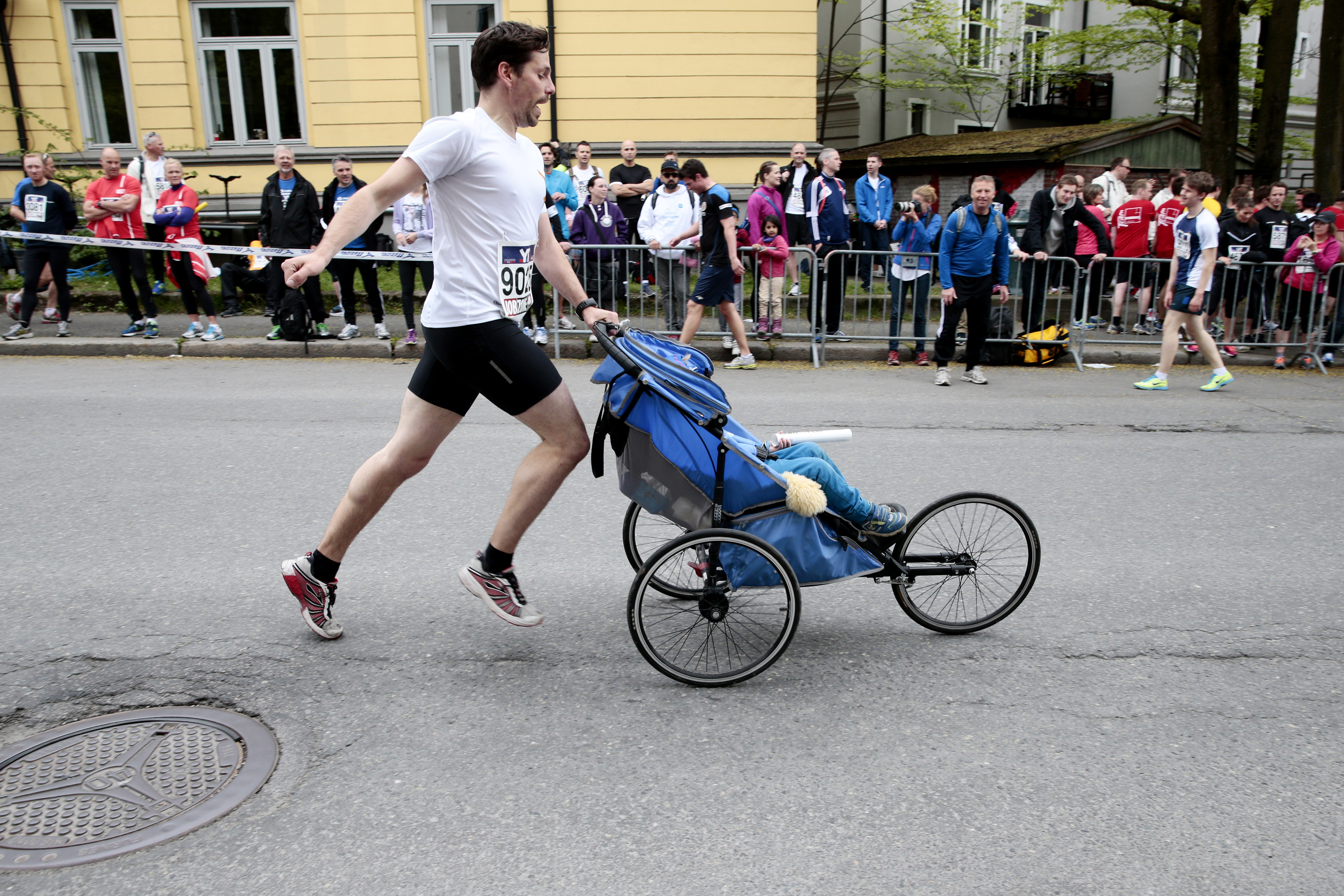Mann løper med barnevogn i Holmekollstafetten i Oslo.